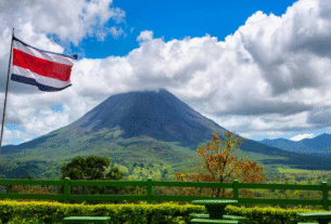 Paisagem natural ao fundo, bancos de madeira e uma bandeira da costa rica